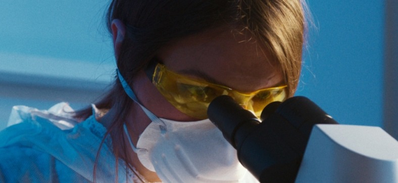 a researcher looking through a microscope